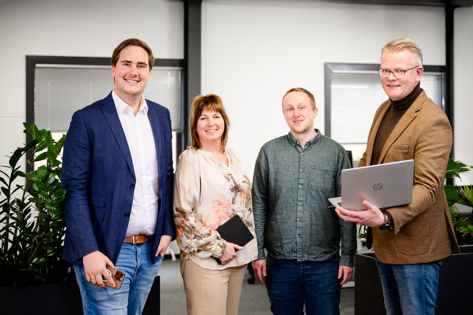 Vier collega's in gesprek in een lichte werkomgeving
