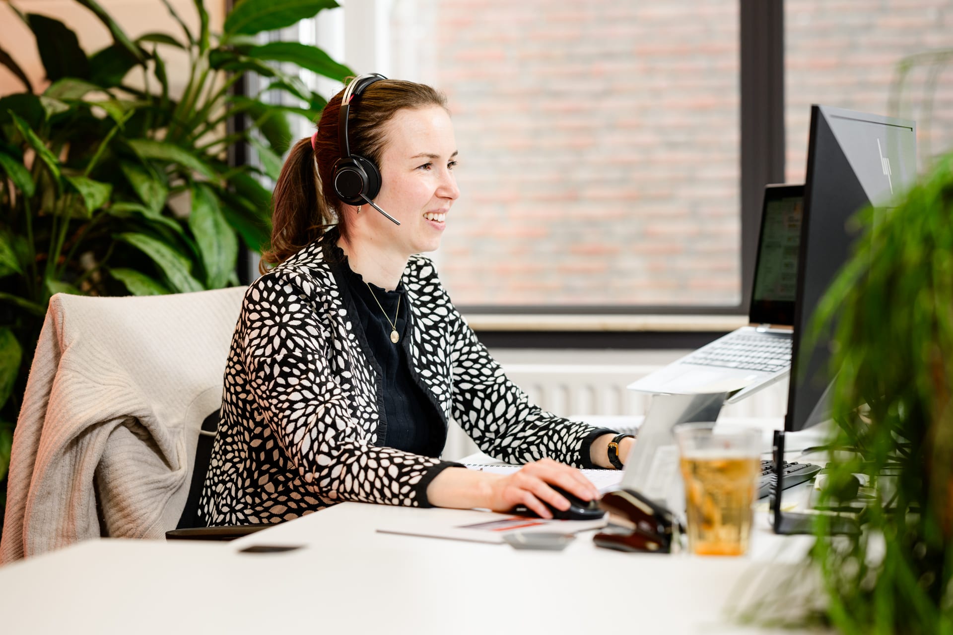Medewerker aan het werk op een lichte kantoorwerkplek